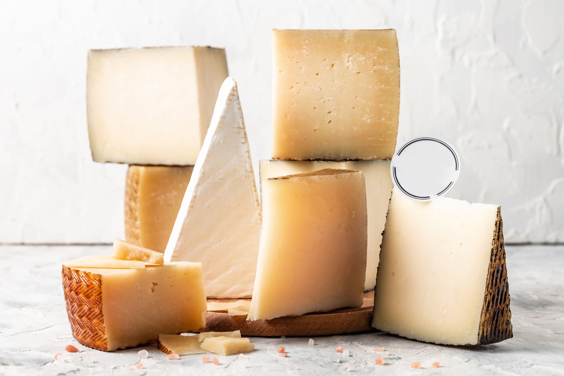 Tagliere di formaggi di vari tipi di formaggi a pasta molle e dura. formaggio spagnolo manchego, prelibatezze casearie internazionali. immagine verticale